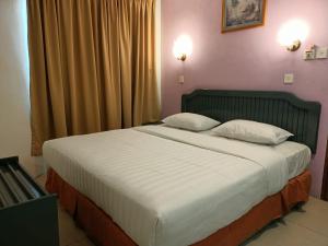 um quarto com uma cama grande e 2 almofadas em Monaco Hotel em Tawau