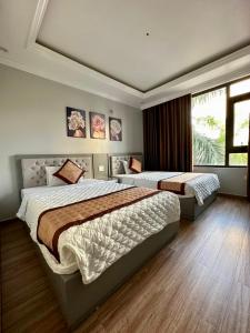 - une chambre avec 2 lits et une fenêtre dans l'établissement Việt Hoàng Hotel Hạ Long, à Hạ Long