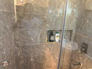 a shower with a glass door with two bottles on it at Aesthetic Functional Minimalist Space Sunvida Tower SV1716 in Cebu City