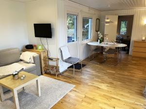 een woonkamer met een bank en een tafel bij Nice cottage located on a seaside plot outside Oskarshamn in Oskarshamn