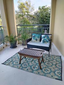 eine Veranda mit einem Sofa und einem Couchtisch auf einem Teppich in der Unterkunft Suite Deluxe vue sur Golf in Juvignac