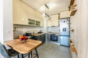 una cucina con tavolo in legno e frigorifero blu di Apartment Saga With Terrace And Parking - Happy Rentals a Zagabria