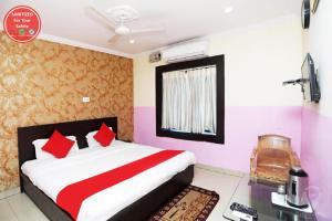 una camera da letto con un grande letto con cuscini rossi di Goroomgo Sai Sand Piper Near Sea Beach Puri a Puri