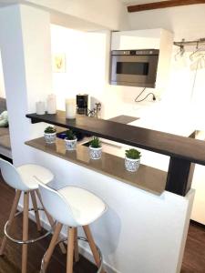 una cocina con 2 taburetes y una barra con microondas en Altstadt Apartment Kempten, en Kempten