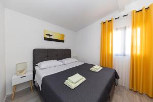 - une chambre avec un lit et 2 serviettes dans l'établissement Family apartments Zadar, à Zadar