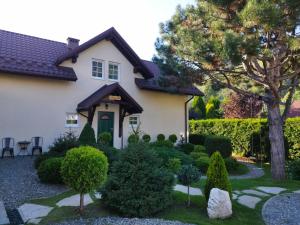 a house with a garden in front of it at Molonówka Guest House in Szczyrk