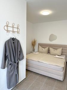 a bed with a coat hanging on a wall at Modernes Haus nähe Parndorf in Bruck an der Leitha