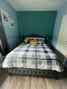 a bedroom with a bed with a blue wall at Double bed Small En-suite for 2 in Killybegs