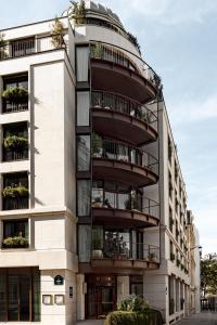 ein Apartmenthaus mit Balkon und ein rundes Gebäude in der Unterkunft Hotel Norman Paris in Paris