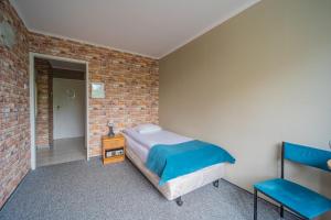 a bedroom with a bed and a brick wall at Hotel Mazowiecki Łódź in Łódź