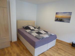 uma cama num quarto com uma fotografia na parede em Gästehaus-City em Helmstedt