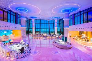 un vestíbulo con una gran sala con mesas y sillas en Le Meridien Qingdao West Coast Resort en Huangdao