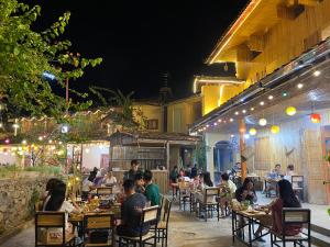 een groep mensen die 's nachts in een restaurant zitten bij Meo Vac Valley in Mèo Vạc