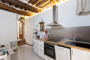 una cocina con fregadero y estufa horno superior en Casa Onda - nel cuore della contrada, en Siena