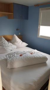ein Bett mit zwei weißen Kissen und einer blauen Wand in der Unterkunft Chalet Sonnenschein in Bredene
