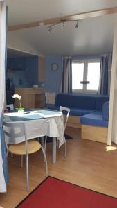 ein Wohnzimmer mit einem Tisch und einem blauen Sofa in der Unterkunft Chalet Sonnenschein in Bredene