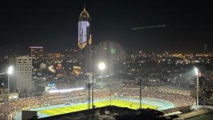 uma multidão de pessoas assistindo a um jogo de futebol à noite em MyFlower 3 Hotel em Arbil