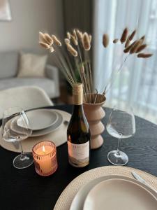 a table with a bottle of wine and two glasses at Esplanaadi Residences in Pärnu