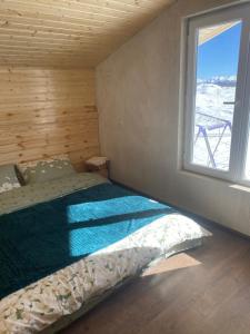 Bett in einem Zimmer mit Fenster in der Unterkunft სასტუმრო ქორულდი / Hotel Koruldi in Mestia