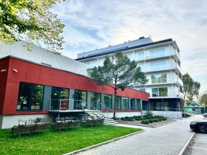 a red and white building with benches in front of it at Esplanaadi Residences in Pärnu