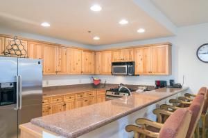 kuchnia z drewnianymi szafkami i lodówką ze stali nierdzewnej w obiekcie Bear Creek Lodge 109A condo w mieście Telluride
