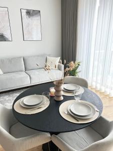 una sala de estar con una mesa con platos. en Esplanaadi Residences en Pärnu