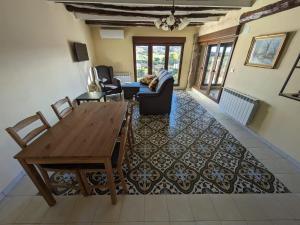 a living room with a wooden table and a couch at Apartamentos Rurales CR Mazaleón in Mazaleón