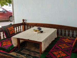 uma mesa com uma tigela de fruta sentada num alpendre em Rice House Near Uzgen 