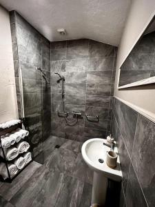 a bathroom with a shower and a sink at Luxurious cottage with cosy fireplace in Matlock in Winster