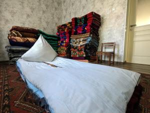 uma cama num quarto com cobertores e uma cadeira em Rice House Near Uzgen 