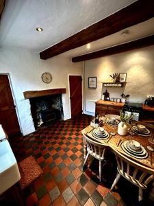 un soggiorno con tavolo e camino di Luxurious cottage with cosy fireplace in Matlock a Winster
