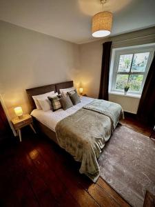 una camera da letto con letto, cuscini e finestra di Luxurious cottage with cosy fireplace in Matlock a Winster