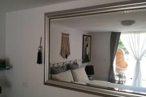 a mirror reflecting a bed in a bedroom at Cristina’s flat Riccione in Riccione