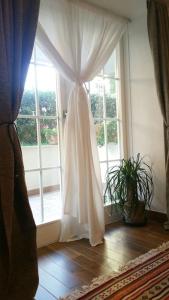 a window with a curtain in front of a door at Cristina’s flat Riccione in Riccione