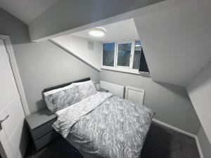 a small bedroom with a bed and a window at Modernised 4 Bedroom House close to city Centre, Kep Stays in Leeds