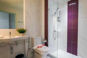 a bathroom with a shower and a toilet and a sink at Grand Pink Hotel Hatyai in Hat Yai