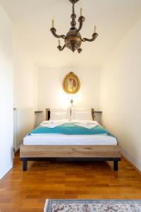 1 dormitorio con 1 cama con lámpara de araña en Vilmos apartman, en Pécs