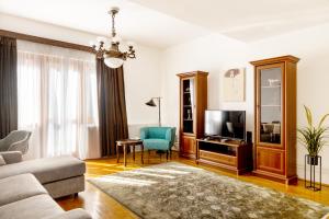 a living room with a couch and a tv at Vilmos apartman in Pécs