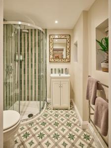 a bathroom with a shower and a sink and a toilet at Guinea Cottage in Great Somerford