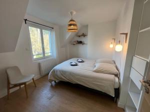 een slaapkamer met een bed, een stoel en een raam bij Maison Touquet pour 4 personnes in Le Touquet-Paris-Plage