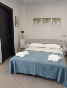 ein Schlafzimmer mit einem Bett mit zwei Handtüchern darauf in der Unterkunft Le Mandorle Apartment in Belpasso