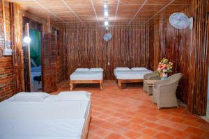 a room with two beds and a table and chairs at HƯNG THÀNH HOME in Ben Tre