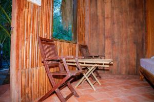 two chairs and a wooden table on a patio at HƯNG THÀNH HOME in Ben Tre