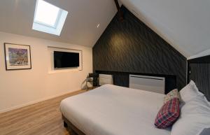 una camera da letto con un letto bianco e una parete nera di Alsace Gîte 3 étoiles "Coeur de Cigogne" - 15mn Strasbourg Obernai - Clim Wifi Parking gratuit a Hangenbieten