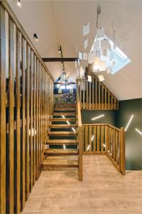 una escalera con barandillas de madera en una habitación en Alsace Gîte 3 étoiles "Coeur de Cigogne" - 15mn Strasbourg Obernai - Clim Wifi Parking gratuit en Hangenbieten