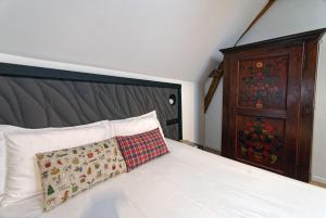 een slaapkamer met een bed met een kussen en een dressoir bij Alsace Gîte 3 étoiles "Coeur de Cigogne" - 15mn Strasbourg Obernai - Clim Wifi Parking gratuit in Hangenbieten