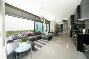 sala de estar con sofá y mesa en Villa Lami - Tropical Modern Loft Phuket with 3BD, private pool, Gym and Sauna en Phuket