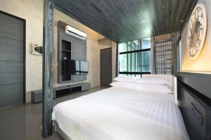普吉市的住宿－Villa Lami - Tropical Modern Loft Phuket with 3BD, private pool, Gym and Sauna，卧室设有一张大白色床和电视。
