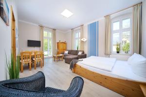 ツィノヴィッツにあるStrandvillen - Wald & Seeのベッドルーム1室(ベッド1台付)、リビングルームが備わります。
