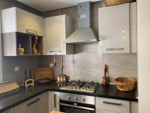a kitchen with white cabinets and a stove top oven at luxe et confort appartement Sahloul 4 in Sousse